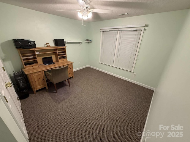 carpeted home office with a textured ceiling and ceiling fan