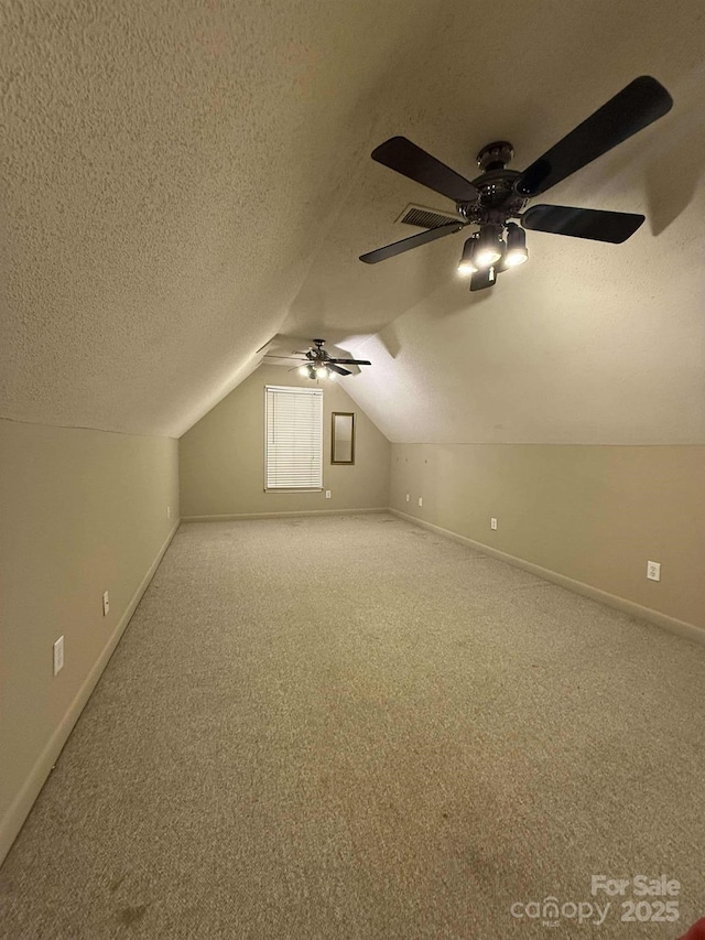 bonus room featuring a textured ceiling, ceiling fan, lofted ceiling, and carpet flooring