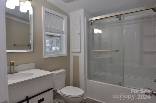 full bathroom featuring toilet, combined bath / shower with glass door, and vanity