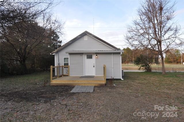 view of front of house featuring a wooden deck and a front lawn