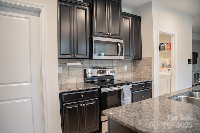 kitchen featuring light stone counters, washer / clothes dryer, appliances with stainless steel finishes, and tasteful backsplash