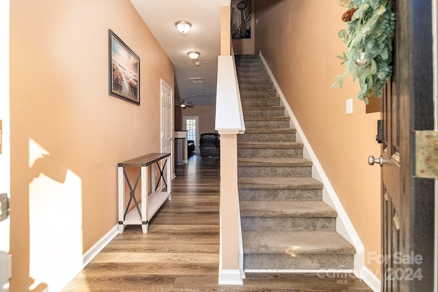 stairs with ceiling fan and hardwood / wood-style floors