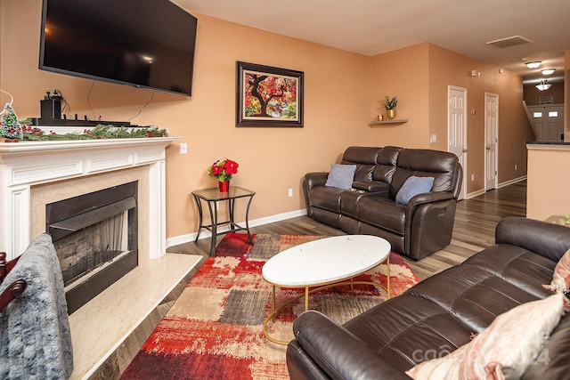 living room featuring dark wood-type flooring and a premium fireplace