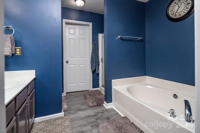 bathroom featuring hardwood / wood-style flooring, vanity, and a bath