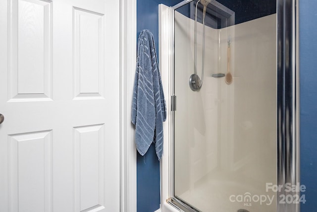 bathroom featuring a shower with door