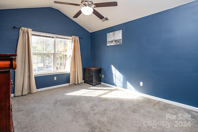 empty room featuring ceiling fan, light colored carpet, and lofted ceiling