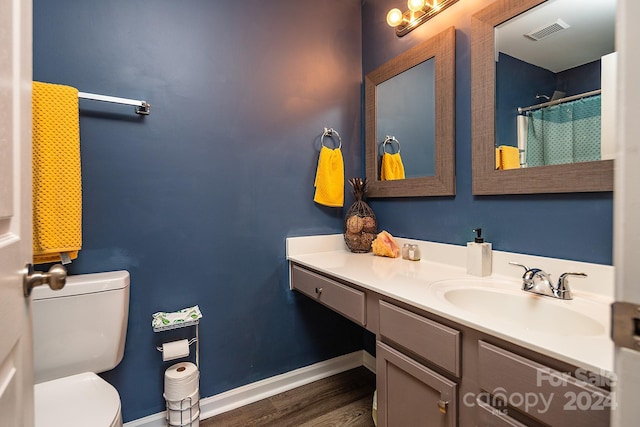 bathroom featuring vanity, hardwood / wood-style flooring, and toilet