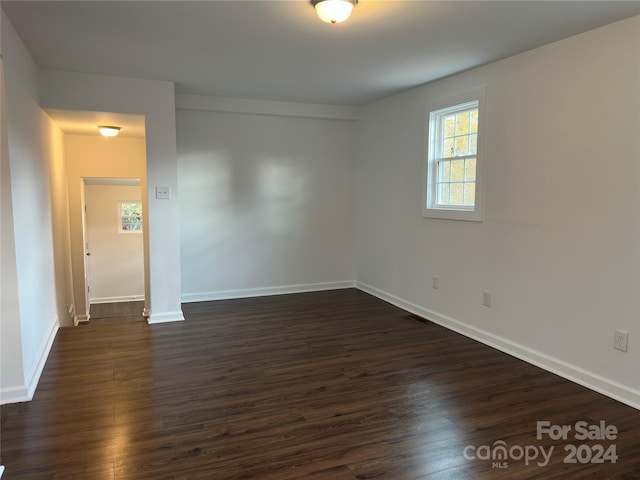 empty room with dark wood-type flooring