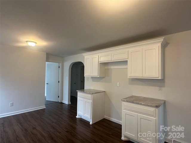 kitchen with white cabinets, dark hardwood / wood-style floors, and light stone countertops