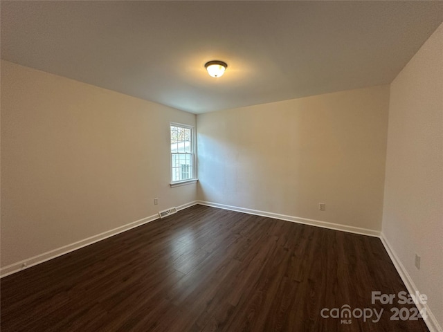 empty room featuring dark wood-type flooring