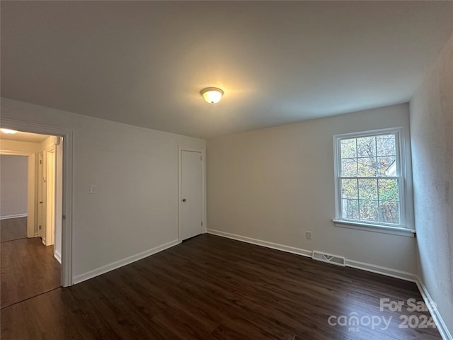 unfurnished room featuring dark wood-type flooring