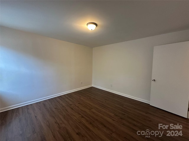 unfurnished room featuring dark wood-type flooring