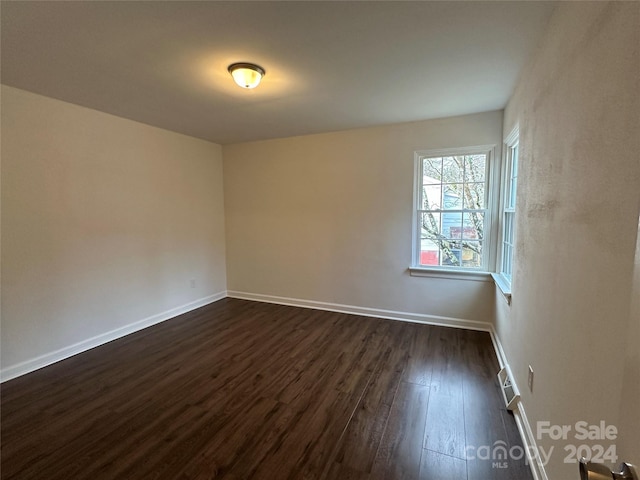 unfurnished room with dark hardwood / wood-style flooring