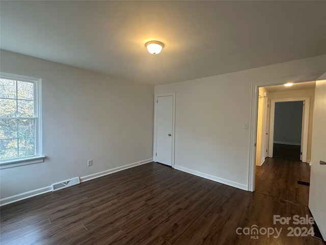 empty room with dark hardwood / wood-style flooring