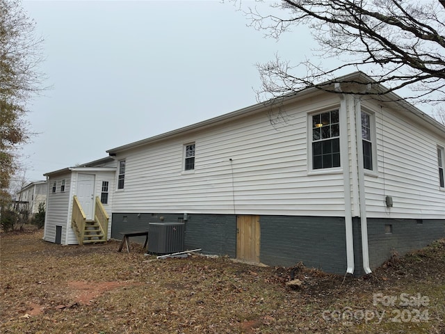 rear view of house featuring central AC