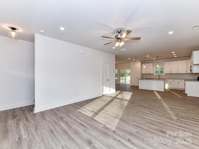 unfurnished living room with visible vents, recessed lighting, light wood finished floors, baseboards, and ceiling fan