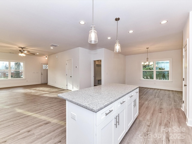 kitchen with plenty of natural light, light wood-style floors, and a kitchen island