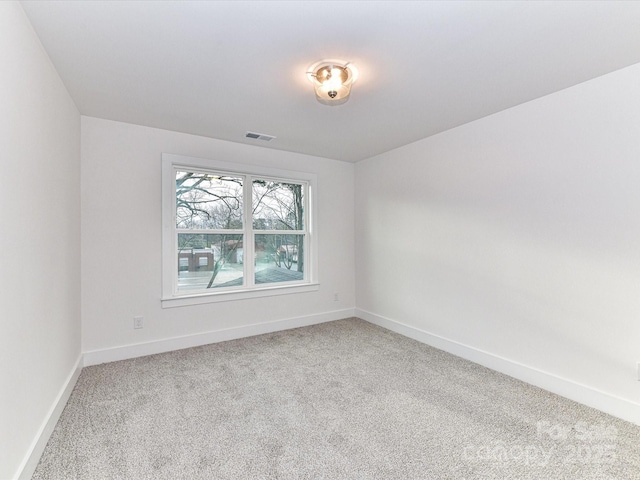 carpeted empty room with baseboards and visible vents