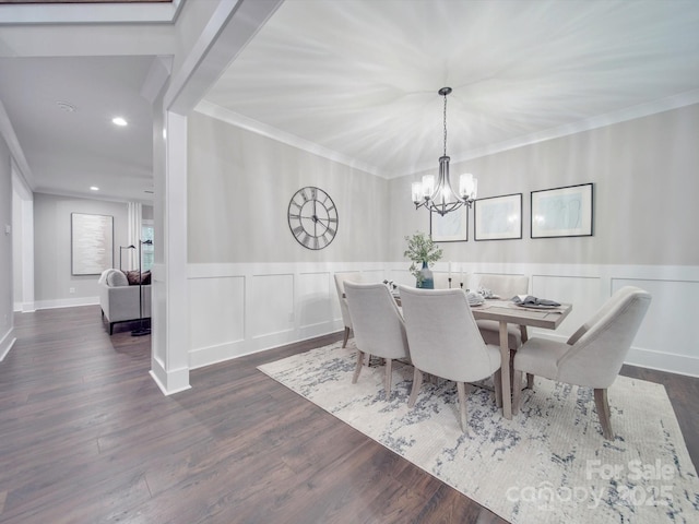 dining area with dark hardwood / wood-style flooring, ornamental molding, and a notable chandelier