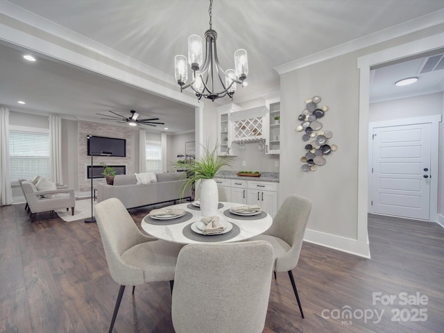 dining room featuring ceiling fan with notable chandelier, dark hardwood / wood-style flooring, and ornamental molding