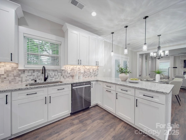 kitchen featuring kitchen peninsula, stainless steel dishwasher, sink, pendant lighting, and white cabinetry