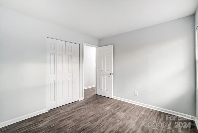 unfurnished bedroom featuring a closet and dark hardwood / wood-style floors