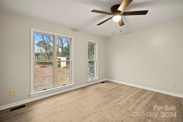 unfurnished room with a wealth of natural light, light hardwood / wood-style flooring, and ceiling fan