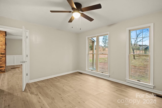 unfurnished room with light wood-type flooring, ceiling fan, and a healthy amount of sunlight