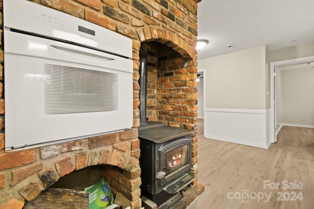 details featuring a wood stove and hardwood / wood-style flooring