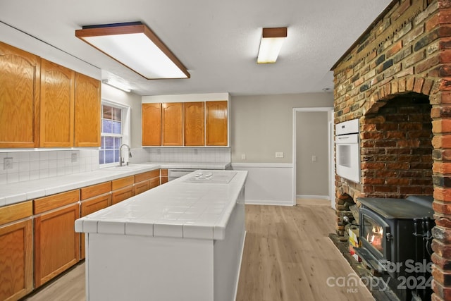 kitchen featuring white oven, tile countertops, and light hardwood / wood-style flooring