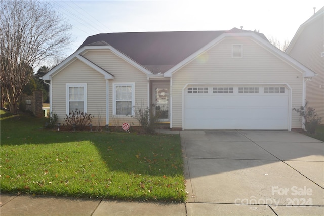 single story home with a garage and a front lawn