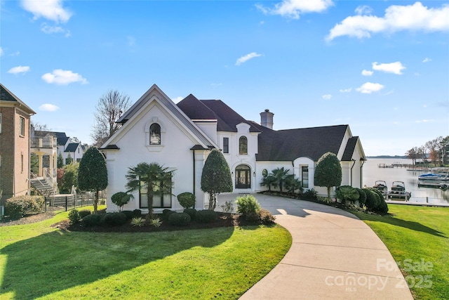 french country inspired facade with a front yard