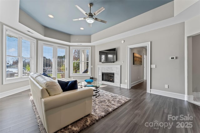 living room featuring dark hardwood / wood-style flooring, a fireplace, and ceiling fan