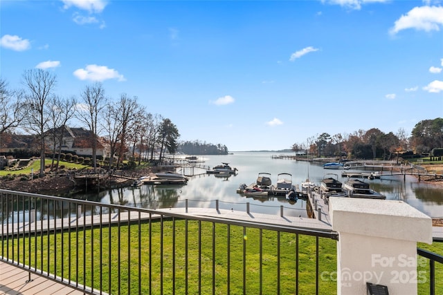 dock area with a lawn and a water view