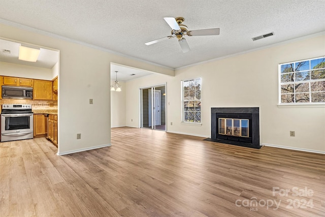 unfurnished living room featuring crown molding, light wood-type flooring, and a textured ceiling