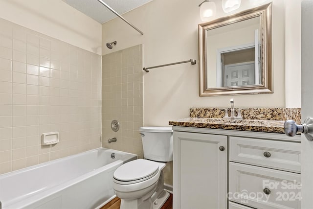 full bathroom with vanity, tiled shower / bath combo, toilet, a textured ceiling, and wood-type flooring