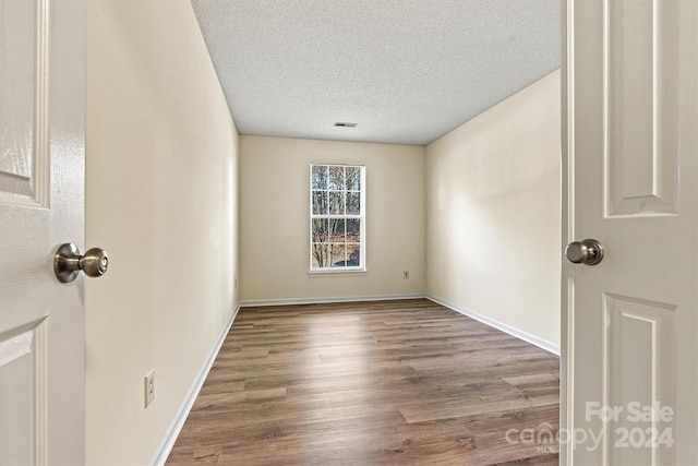 empty room featuring hardwood / wood-style floors and a textured ceiling