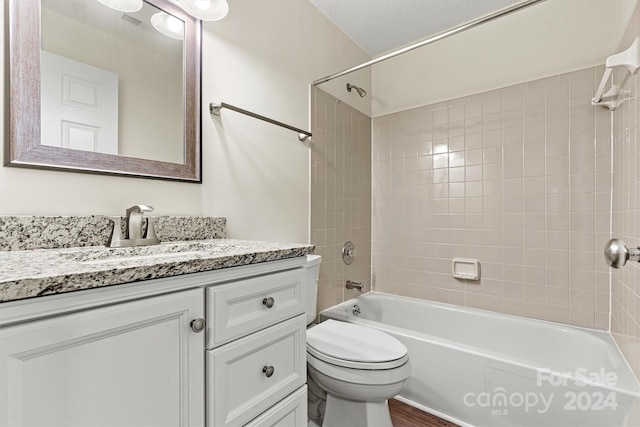 full bathroom featuring toilet, vanity, hardwood / wood-style flooring, and tiled shower / bath combo