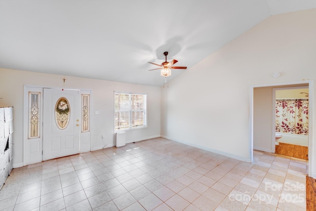 foyer entrance featuring ceiling fan, vaulted ceiling, baseboards, and light tile patterned floors