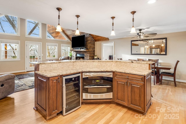 kitchen with wine cooler, ceiling fan, light hardwood / wood-style flooring, and hanging light fixtures