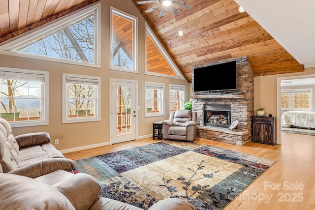 living room featuring ceiling fan, wooden ceiling, and a fireplace