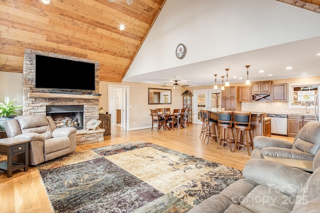 living room featuring ceiling fan, high vaulted ceiling, wooden ceiling, a fireplace, and light hardwood / wood-style floors