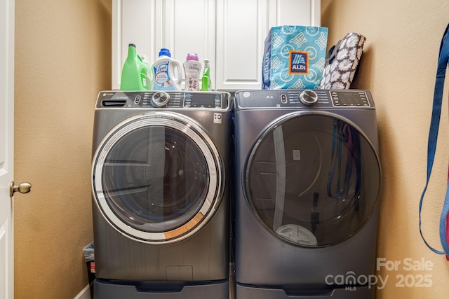 laundry room with washer and dryer and cabinets