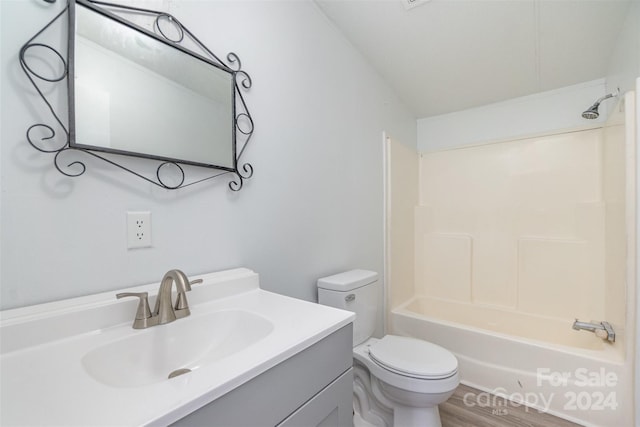 full bathroom featuring hardwood / wood-style floors, vanity, toilet, and shower / washtub combination