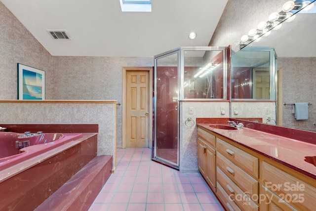 bathroom featuring vanity, tile patterned flooring, vaulted ceiling with skylight, and separate shower and tub