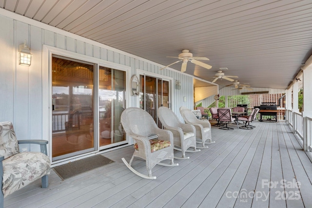 wooden terrace with area for grilling and ceiling fan