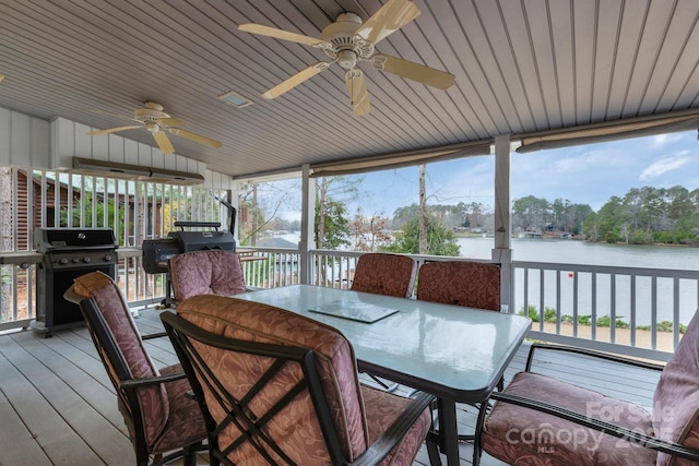 sunroom featuring a water view