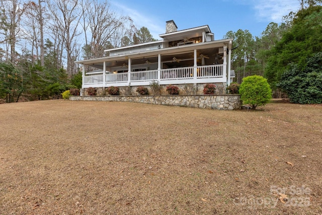 view of front of house with covered porch, ceiling fan, and a front lawn