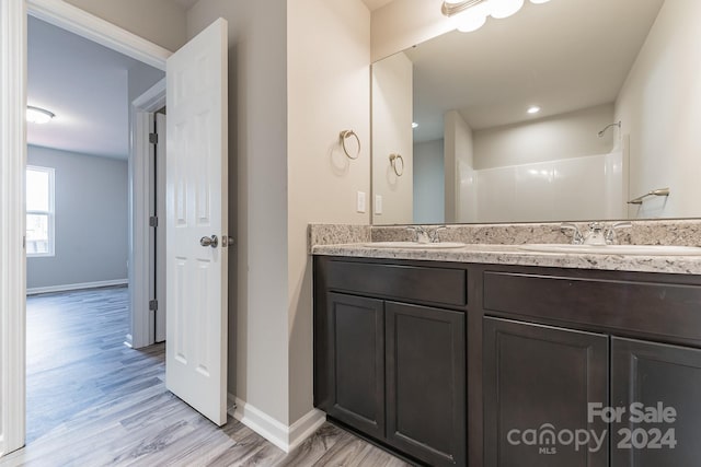 bathroom featuring vanity, a shower, and wood-type flooring