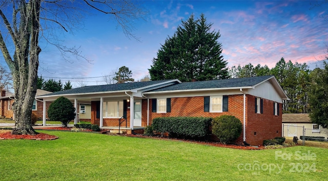 single story home with a porch and a yard